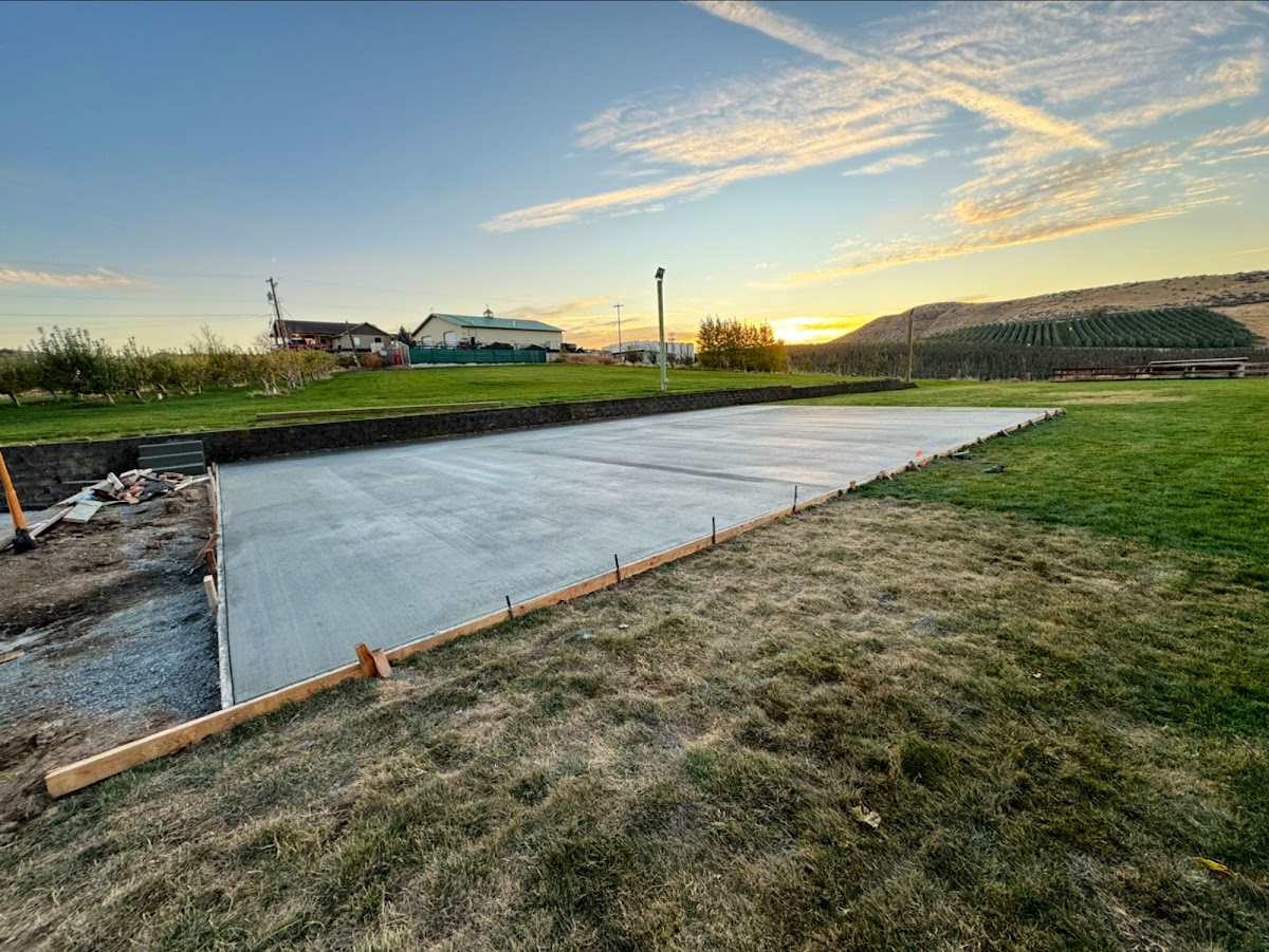 Large concrete slab poured at golden hour with the Yakima Valley orchards behind