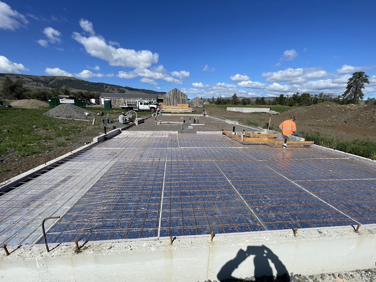 A Premier Concrete crew member working a rebar-grid foundation pour